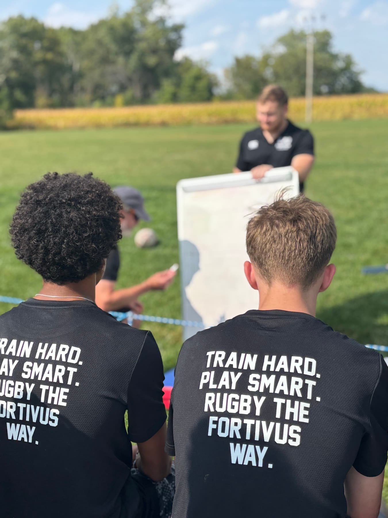 Fortivus athletes listening to a coach during a field session