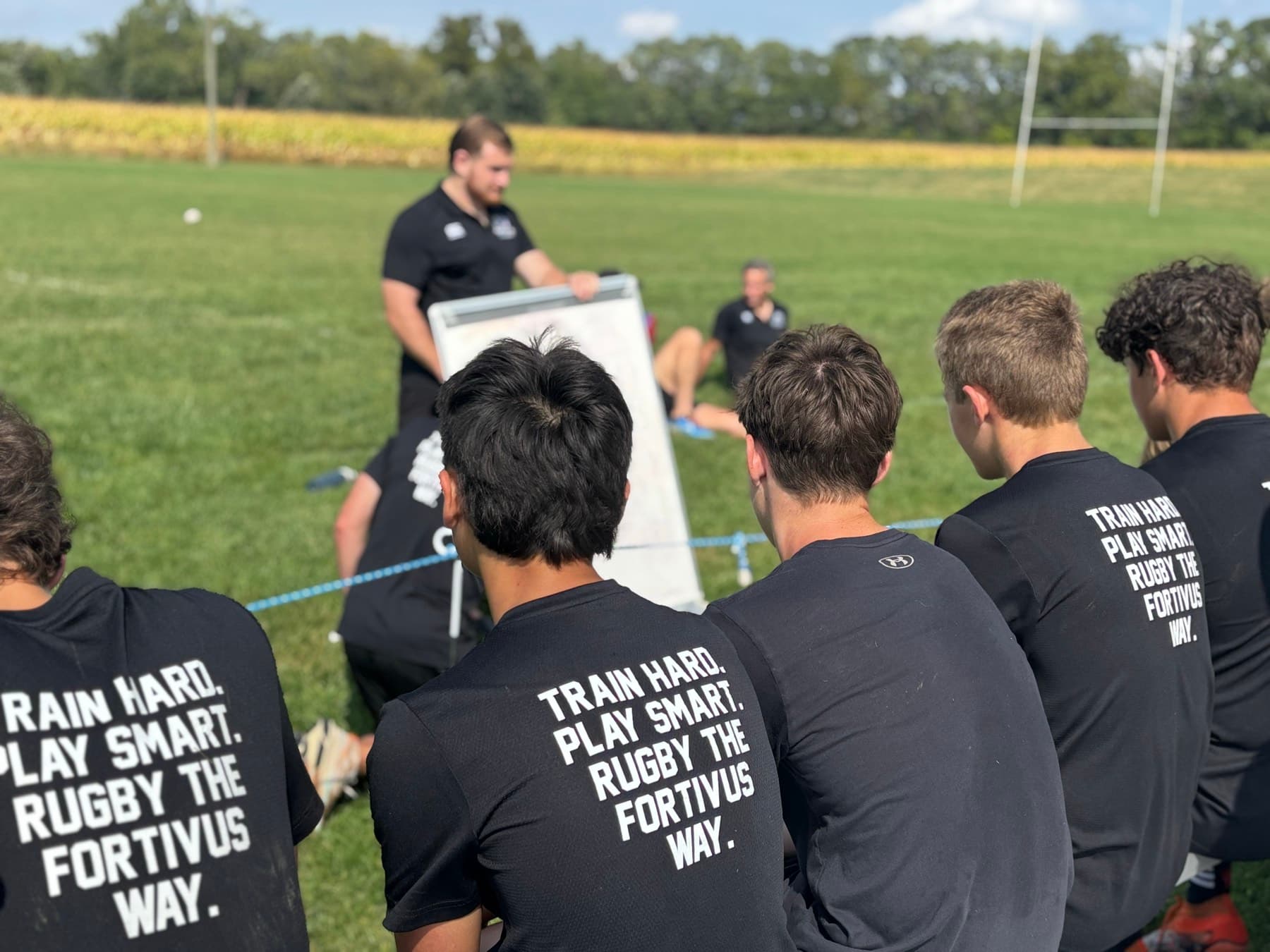 Fortivus athletes listening to a coach during a field session