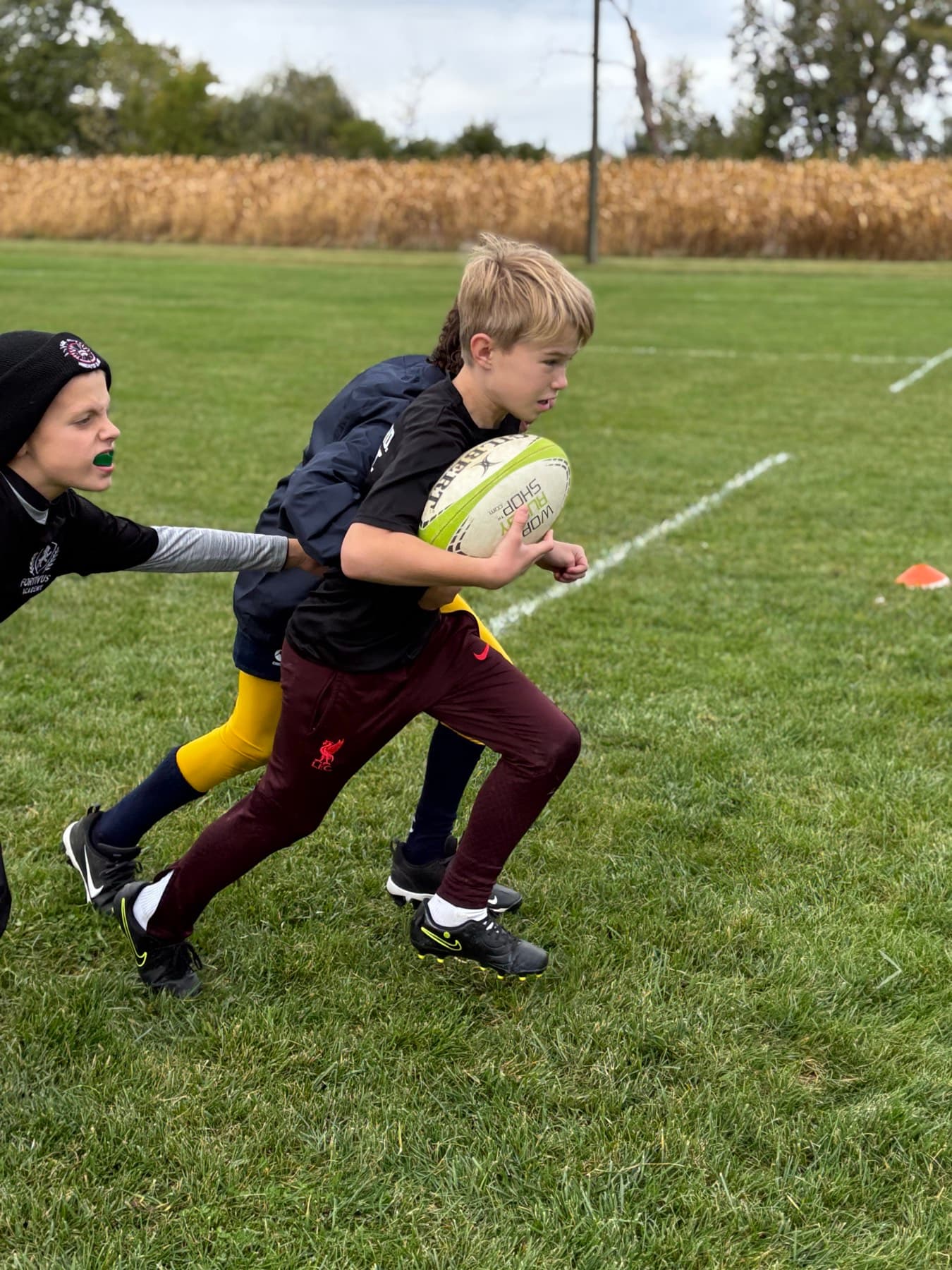 A young Fortivus player carrying the ball during a beginner drill